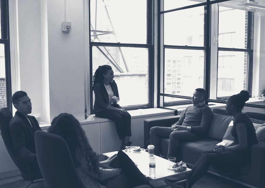 A founding team gathered in a bright office, talking together